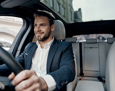 Smiling man sitting in a business lease car